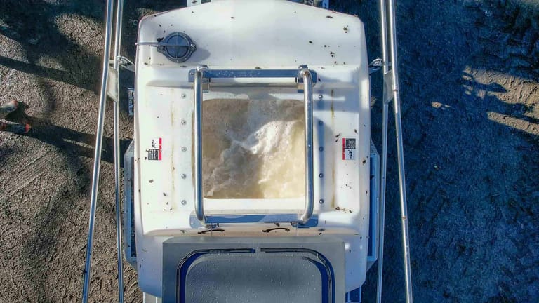 Top-down view of the Tow and Fert Multi 2800 sprayer, showing liquid swirling inside the tank through the fertiliser filling opening.