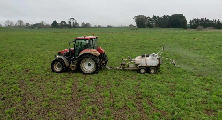 Tractor pulling a Tow and Fert Multi 1000 across a paddock in Cambridge, NZ